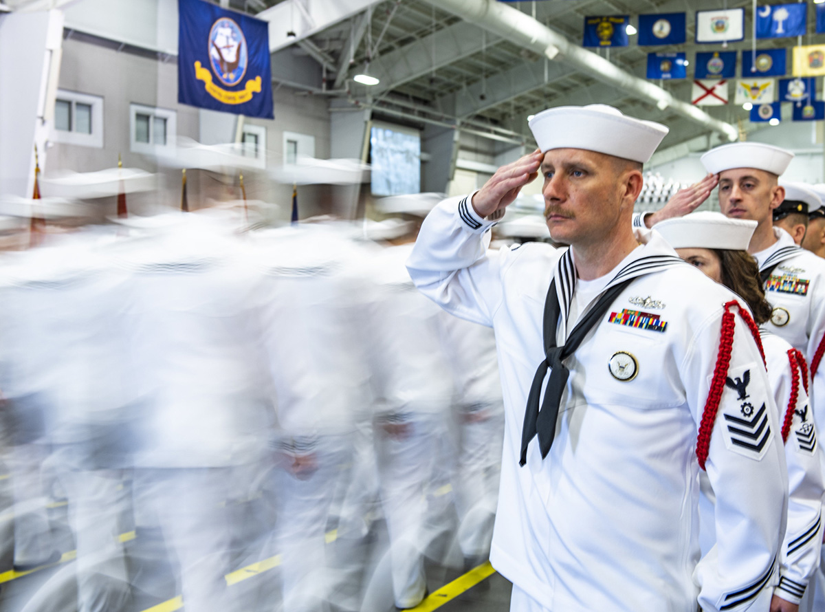 Recruit division commanders salute graduating divisions as they enter Midway Ceremonial Drill Hall on June 14, 2019, during a pass in review graduation ceremony at Recruit Training Command at Great Lakes, Ill. More than 35,000 recruits train annually at the Navy's only boot camp. (Mass Communication Specialist 1st Class Spencer Fling/Navy)