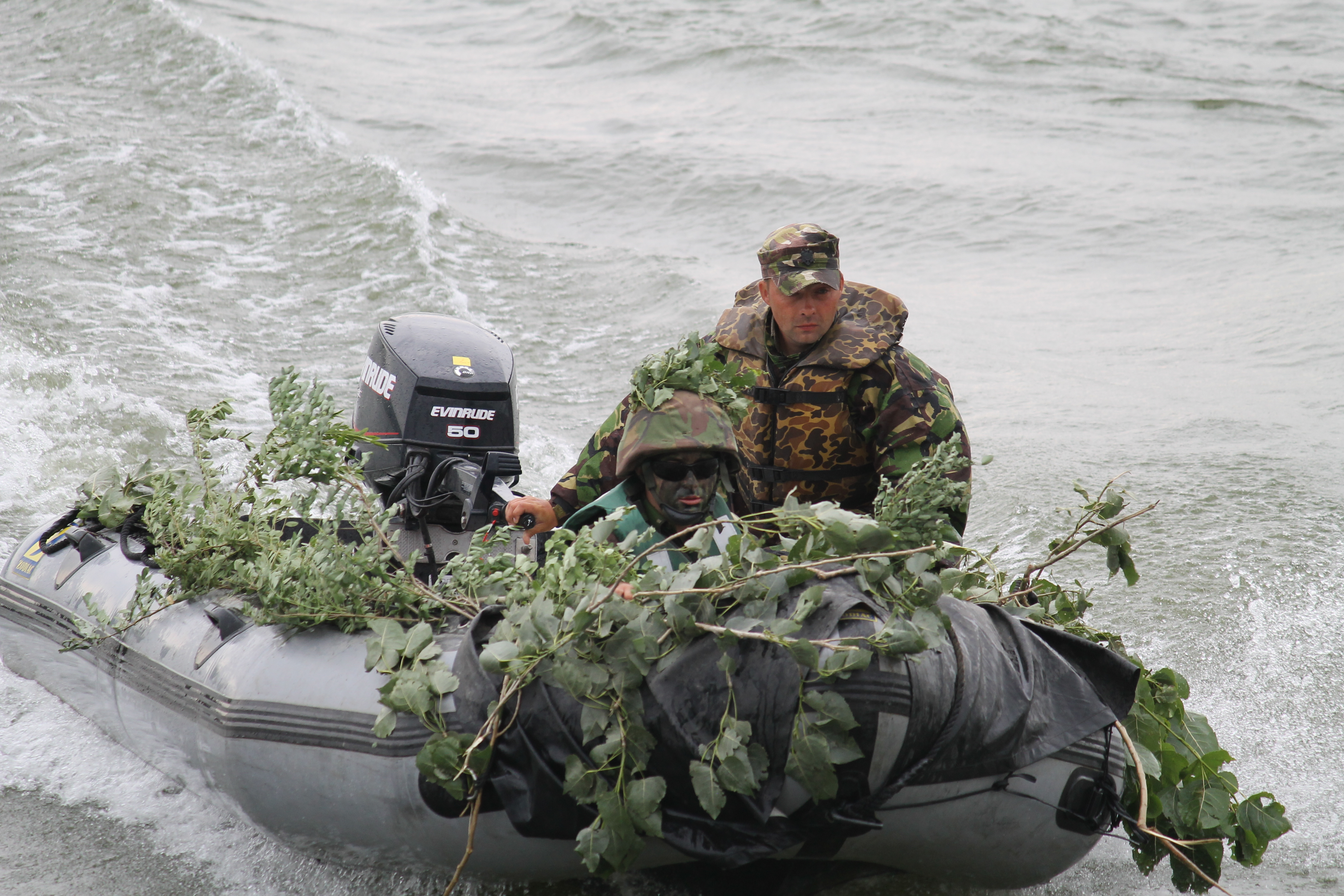 A camouflaged raft zips across the Danube, picking up more troops to carry back. The process of moving units across the river several times took just a few minutes. (Jen Judson/Staff)