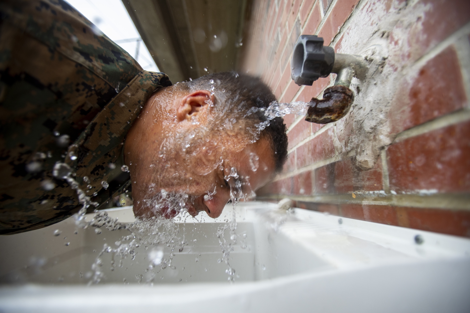 A Marine attached to Deployment Processing Command Reserve Support Unit-East, Force Headquarters Group, runs water on his face after gas chamber training at Marine Corps Base Camp Lejeune, N.C., Oct. 22, 2019. (Sgt. Andy O. Martinez/Marine Corps)