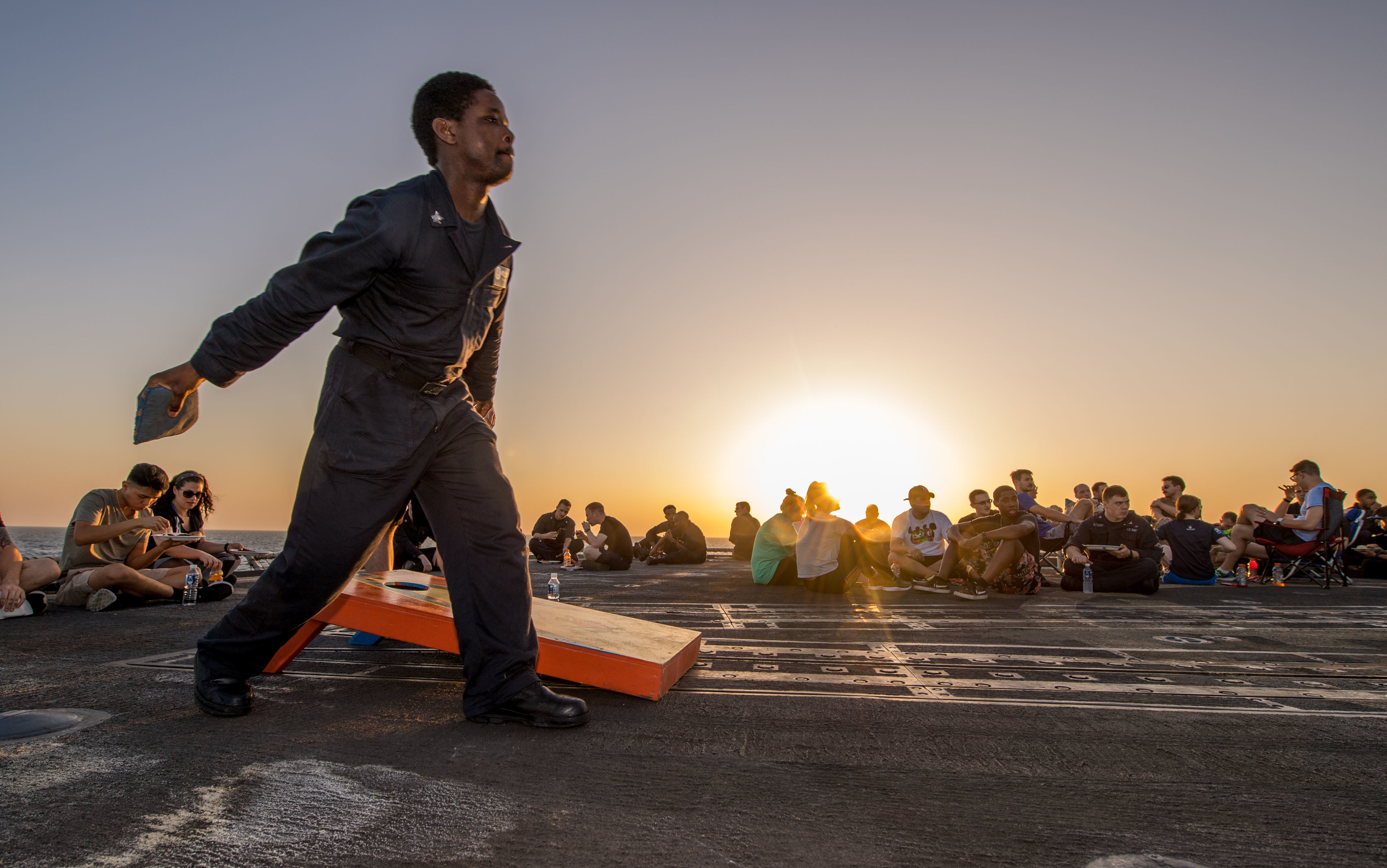 Information Systems Technician 2nd Class Philmore Daley, from Lemoore, Calif., plays cornhole during a steel beach picnic on the flight deck of the Ticonderoga-class guided-missile cruiser USS Princeton (CG 59), Oct. 15, 2017. (Mass Communication Specialist 3rd Class Kelsey J. Hockenberger/Navy)
