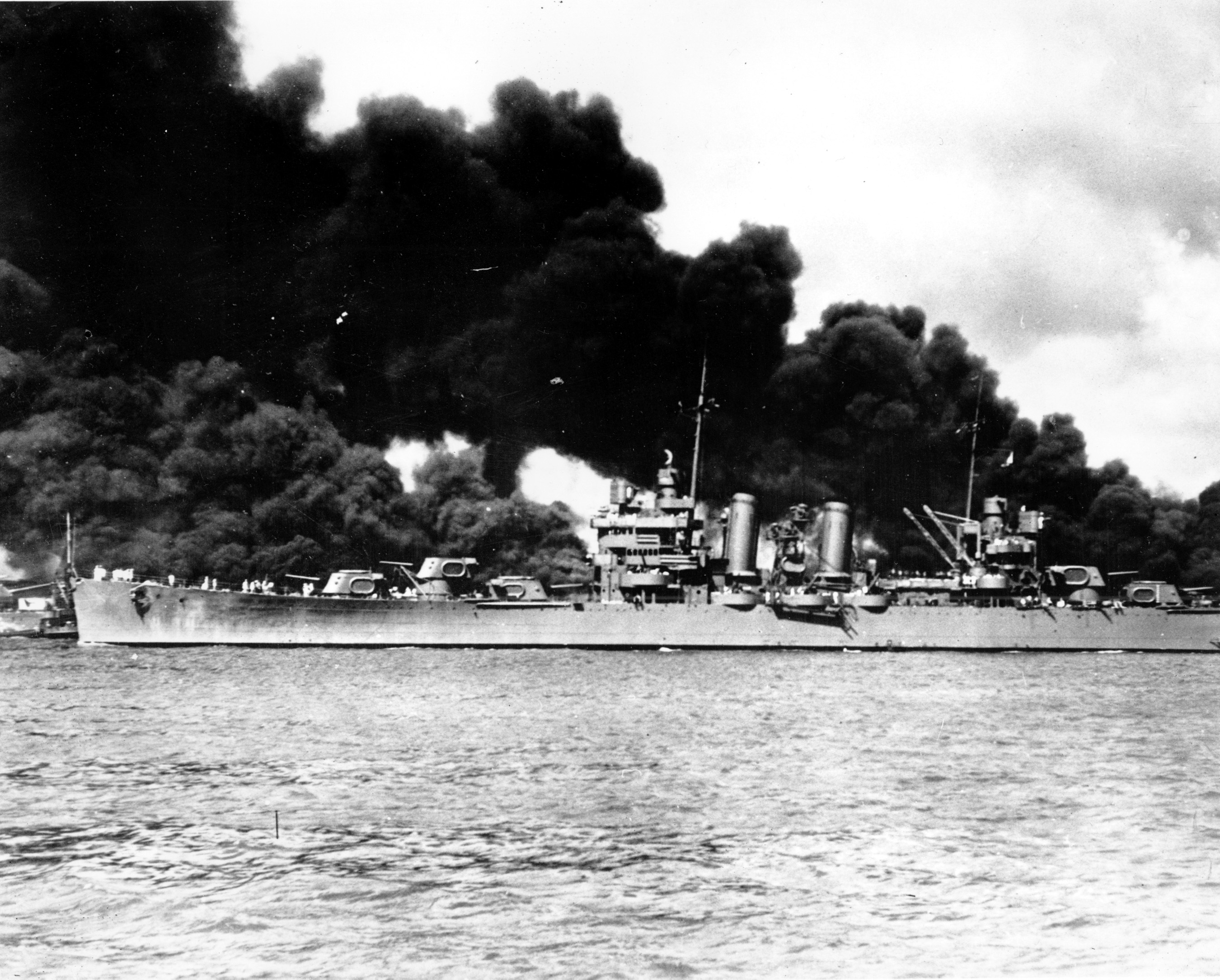 An undamaged light cruiser steams out past the burning USS Arizona and takes to sea with the rest of the fleet during the Japanese aerial attack on Pearl Harbor, Hawaii, on Dec. 7, 1941 during World War II. (AP Photo/U.S. Navy)