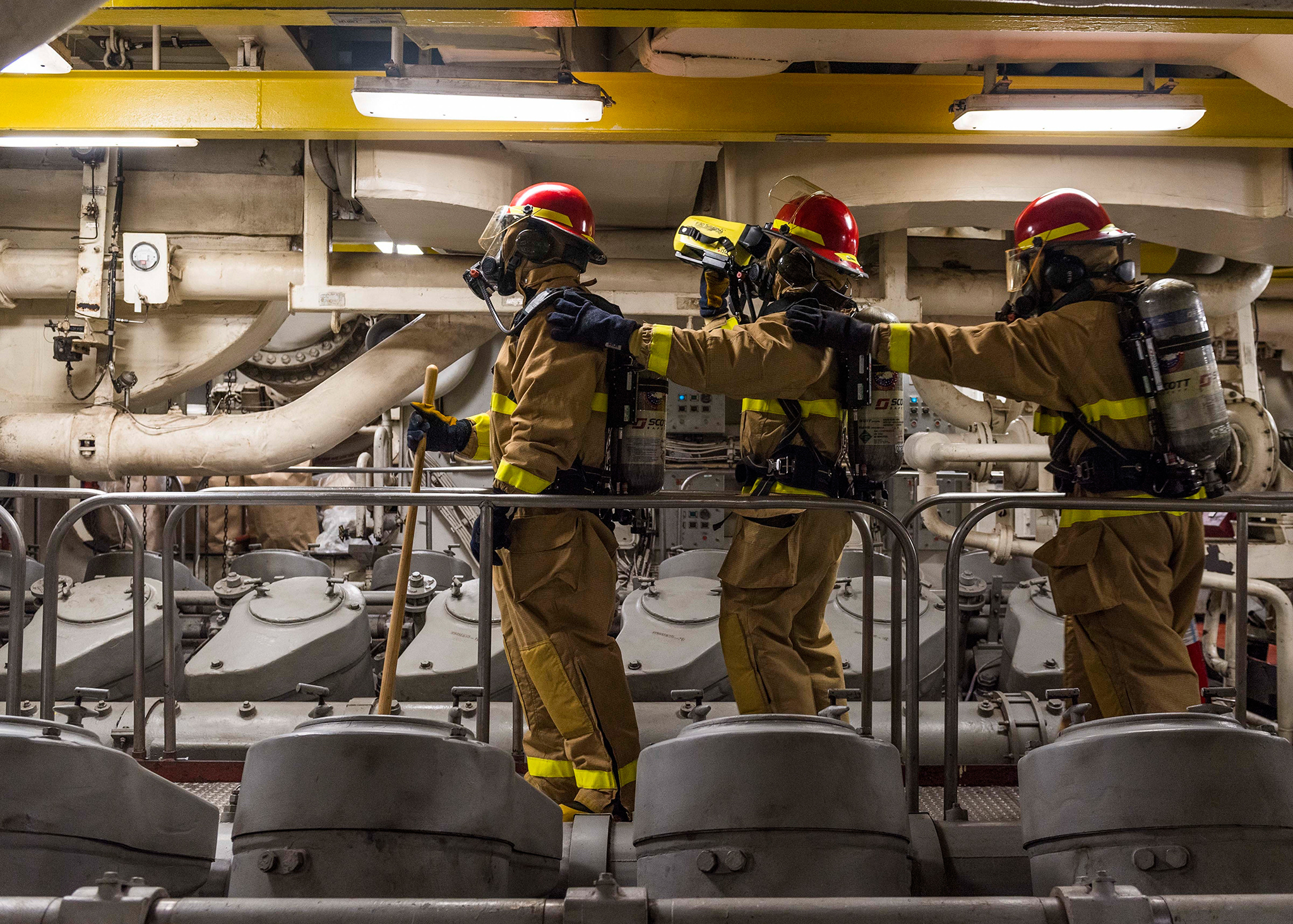 Sailors simulate overhauling a space using a Naval Firefighting Thermal Imager on Feb. 13, 2019, during a main space fire drill in the Main Machinery Room (MMR) 2 of the amphibious dock landing ship USS Ashland (LSD 48) in the South China Sea. (Mass Communication Specialist 2nd Class Markus Castaneda/Navy)