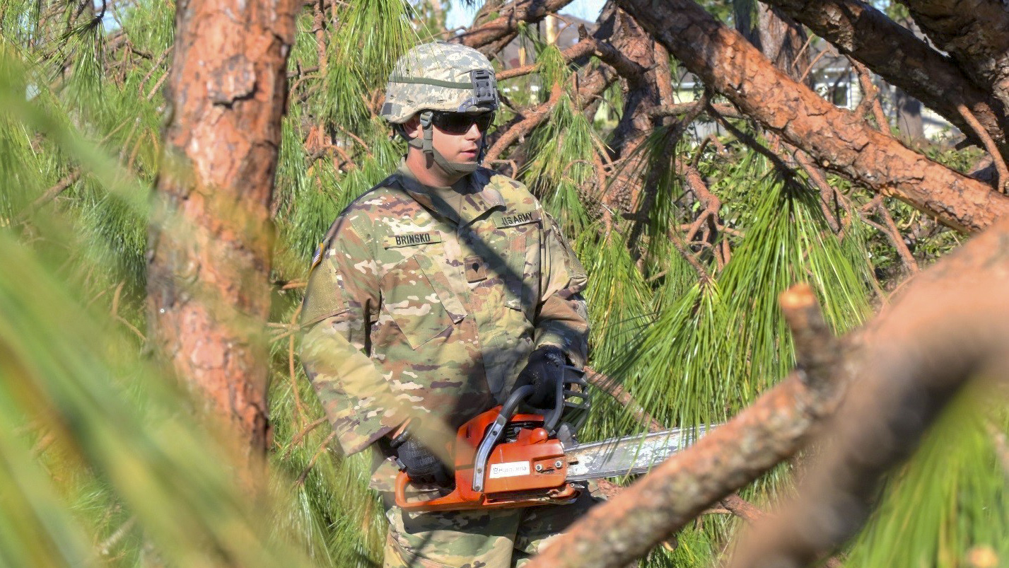 Florida National Guard Spc. Thomas Brinsko, with the 753rd Brigade Engineer Battalion, Alpha Co., from Tallahassee, Florida, cuts and removes tree branches from the roadways after the strike of Hurricane Michael, Oct. 13, 2018, in Panama City, Florida. (Pfc. Arcadia Jackson/National Guard)