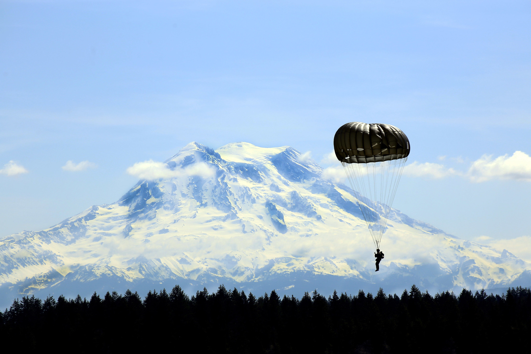 A Guardsman with Alpha Company, 1st Battalion, 19th Special Forces Group parachute past Mount Rainier on Joint Base Lewis-McChord on May 5, 2019. (Joseph Siemandel/National Guard)