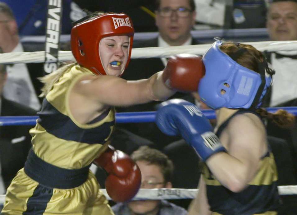 Mikayla Lint (in gold) hits Darcy Stack, right, (in blue) during the 139 lb weight class bout at the United States Naval Academy's 77th Brigade Boxing Championships held on Feb. 23, 2018. (Alan Lessig/Staff)