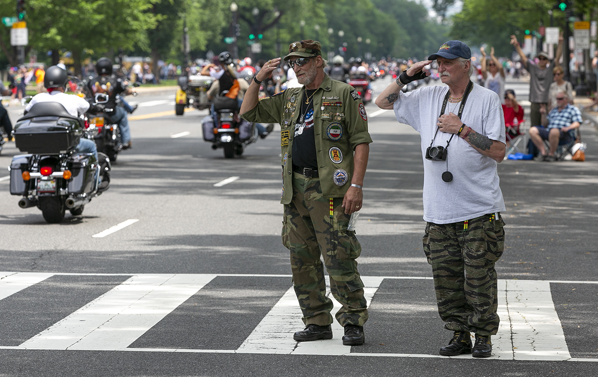 Navy veterans and brothers Mark, left, and John Brancaccio, right, salute riders as they pass them along Constitution Ave during Rolling Thunder XXXI First Amendment Demonstration Run in Washington, DC on Sunday May 27, 2018. Motorcycle riders from across the nation, rode a designated route through the Mall area of Washington, D.C. The event is an actual demonstration/protest to bring awareness and accountability for POWs and MIAs left behind.(Alan Lessig/Staff)