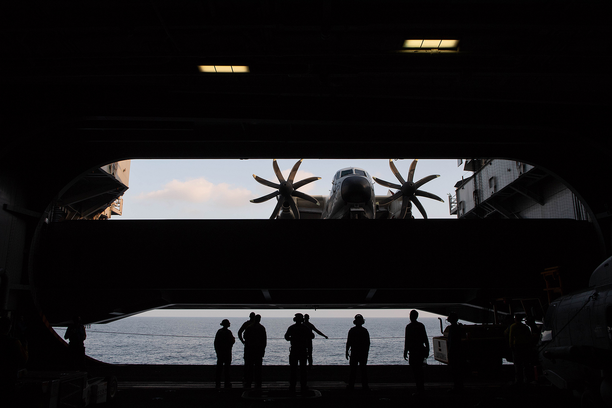 Sailors observe a C-2A Greyhound from the flight deck to the hangar bay on an aircraft elevator aboard the aircraft carrier USS John C. Stennis (CVN 74) on Jan. 24, 2019, in the Indian Ocean. (Mass Communication Specialist Seaman Joshua L. Leonard/Navy)