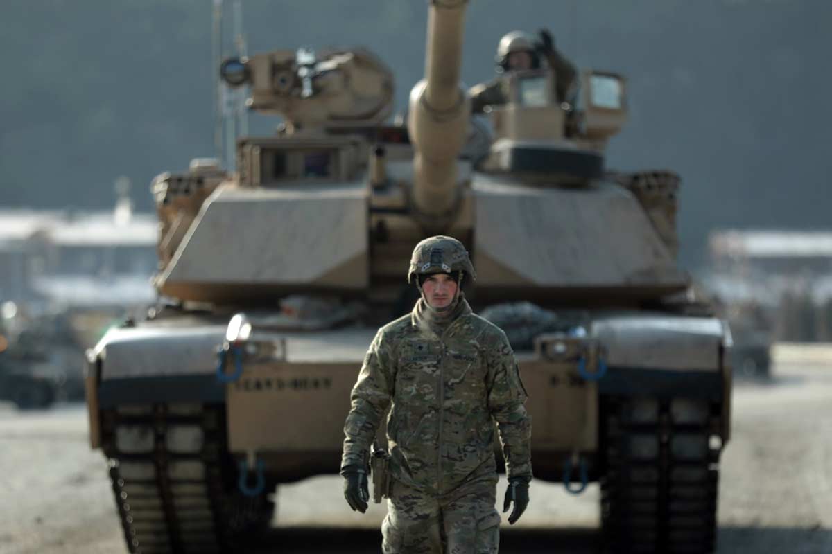 A tank crewman with 3rd Battalion, 8th Cavalry Regiment, 3rd Armored Brigade Combat Team, 1st Cavalry Division, ground guides his tank in the Republic of Korea, Nov. 19, 2019, during the battalion's gunnery qualifications. (Capt. Scott Kuhn/Army)