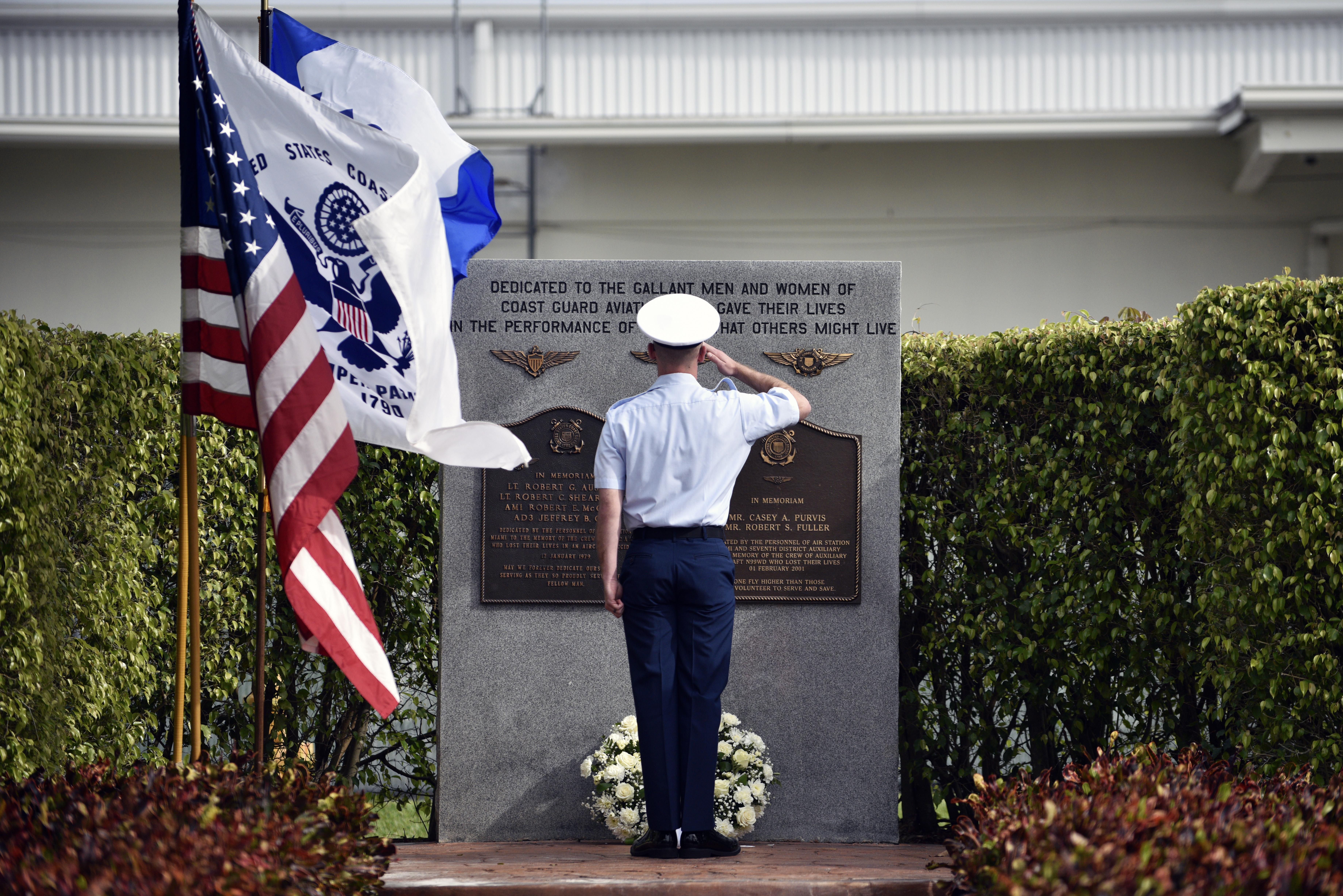 A Coast Guard Air Station Miami crew member salutes a memorial after laying a wreath during a remembrance ceremony in Miami, Florida, on Jan. 17, 2018. The annual ceremony honors those air crew members who've lost their lives in the line of duty in the Miami area. (Coast Guard photo by Eric D. Woodall)