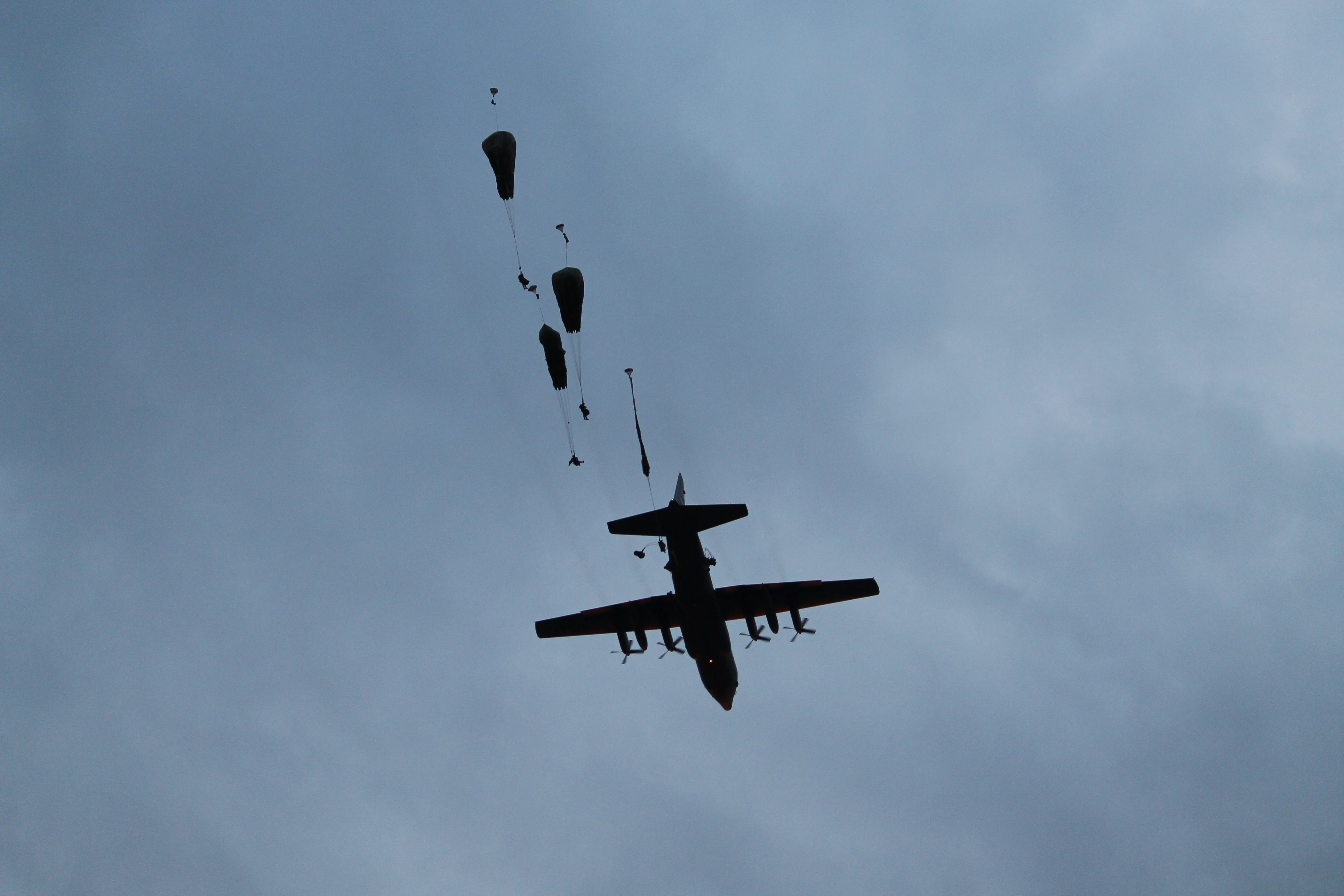 A C-130 flies overhead as paratroopers begin to jump out. The 13 aircraft used in Swift Response deposited hundreds of paratroopers at Bezmer over the course of roughly an hour. An estimated 1,000 paratroopers participated in Swift Response. (Jen Judson/Staff)