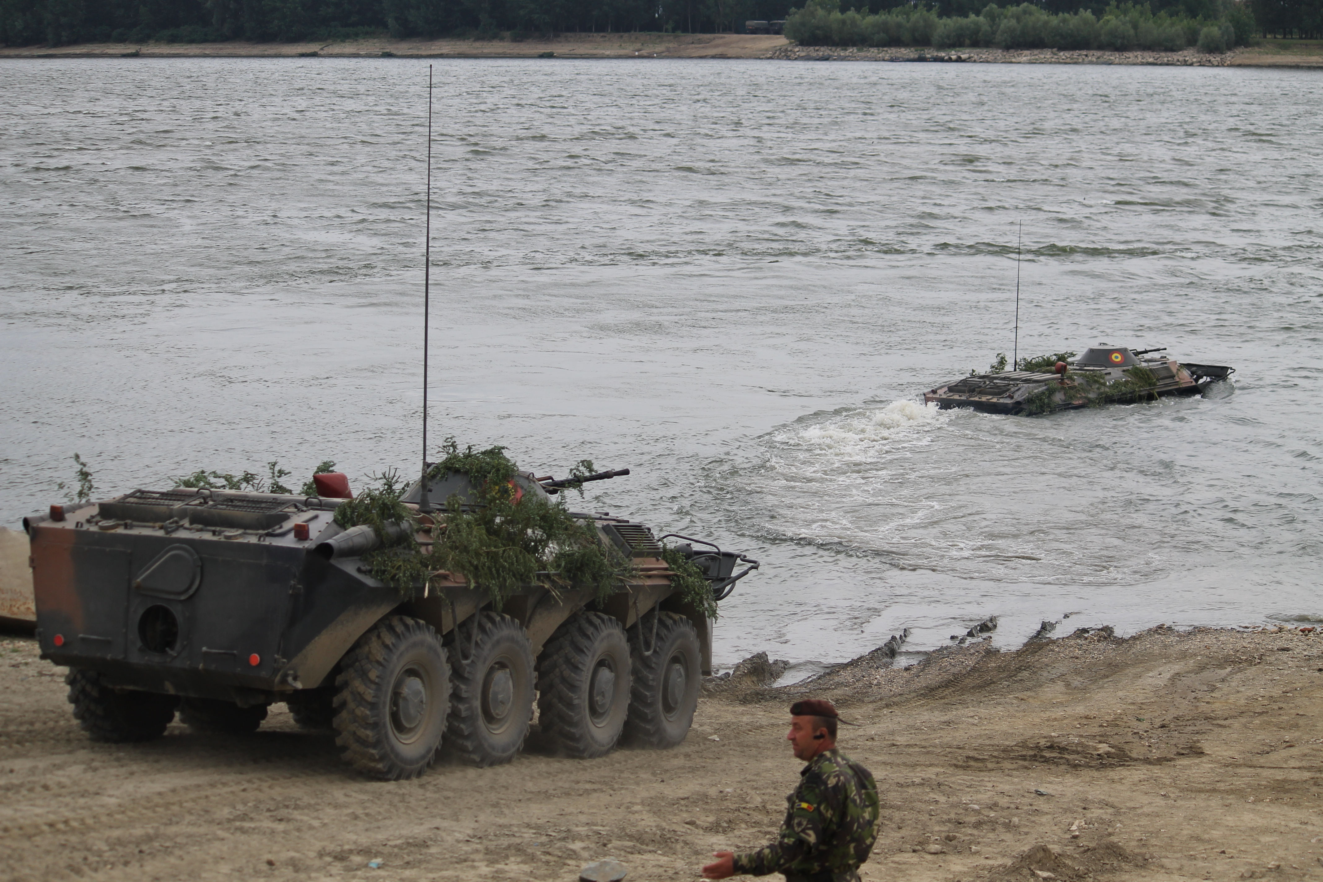 Romanian BTR armored vehicles move into the river as troops fire their guns. Using armored vehicles to swim the Danube is a move the Soviets developed in the Warsaw Pact and practiced regularly. The Romanians brought back the capability during the exercise using an entire company of BTRs. (Jen Judson/Staff)