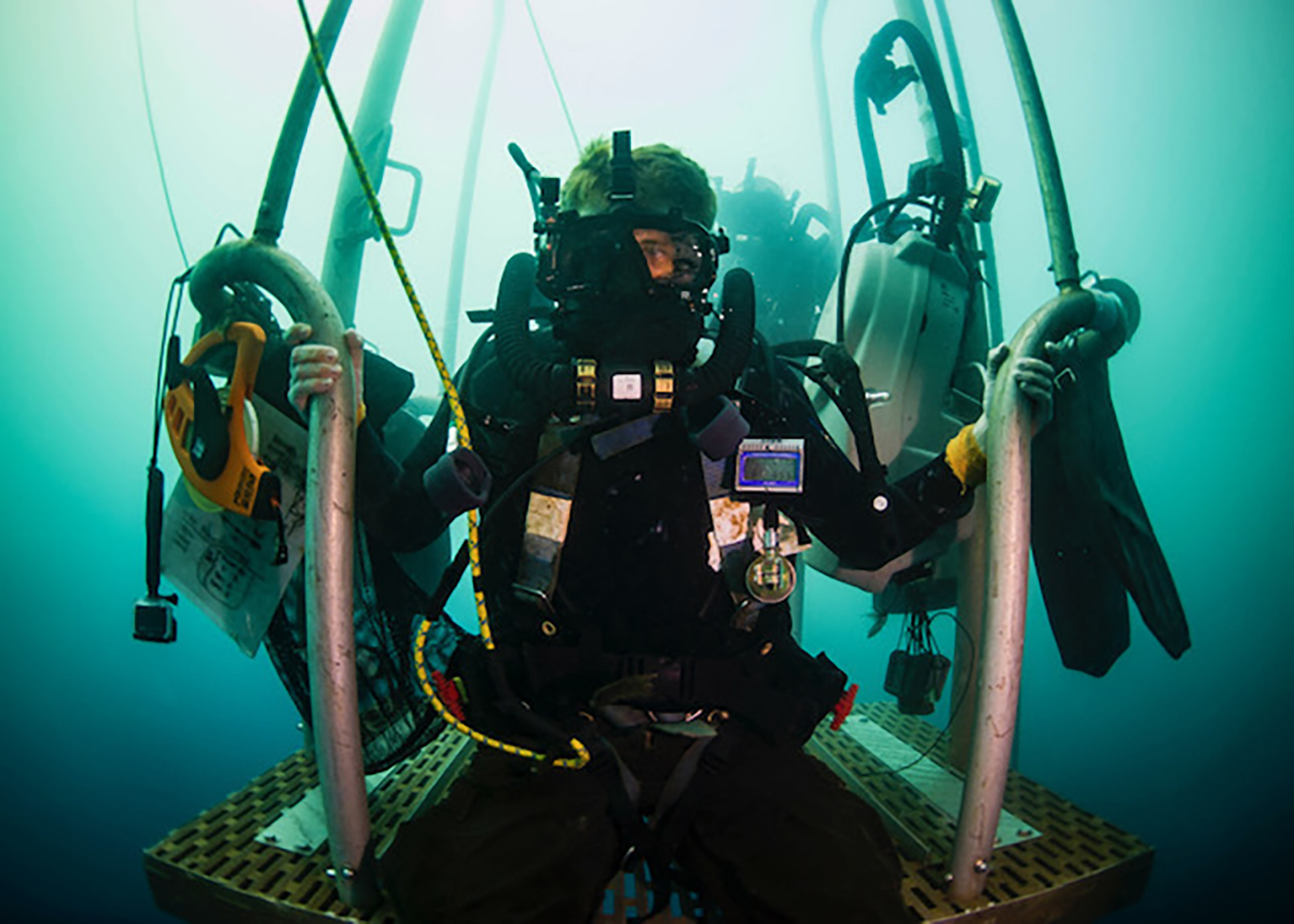 Navy Diver 1st Class James Mostek waits on a diving stage during a two-hour decompression stop after diving to 240 feet on Dec. 7, 2018. The sailor completed a Defense POW/MIA Accounting Agency underwater recovery mission searching for personnel who went missing during WWII in Papua New Guinea. (MC1 Tyler Thompson/Navy)