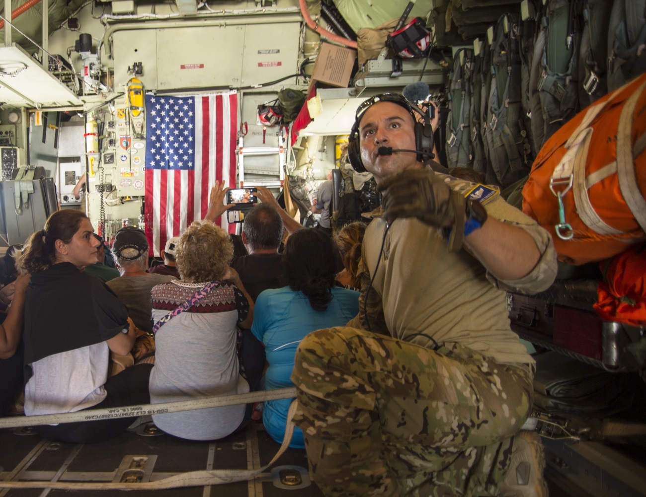 Master Sgt. James Brucculeri, loadmaster with the 103rd Rescue Squadron, ushers evacuees onto a HC-130 on St. Maarten headed to San Juan, Puerto Rico, on Sept. 10, 2017. (Staff Sgt. Erin Mills/Air Force)