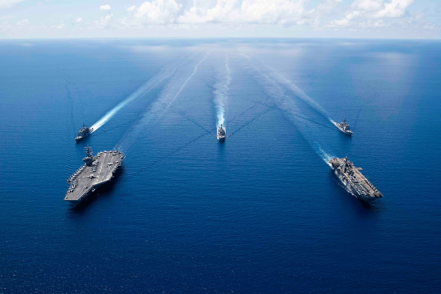 The aircraft carrier USS Ronald Reagan (CVN 76), left, and the amphibious assault ship USS Boxer (LHD 6) and ships from the Ronald Reagan Carrier Strike Group and the Boxer Amphibious Ready Group are underway in formation Oct. 6, 2019, in the South China Sea. (Mass Communication Specialist 2nd Class Erwin Jacob V. Miciano/Navy)