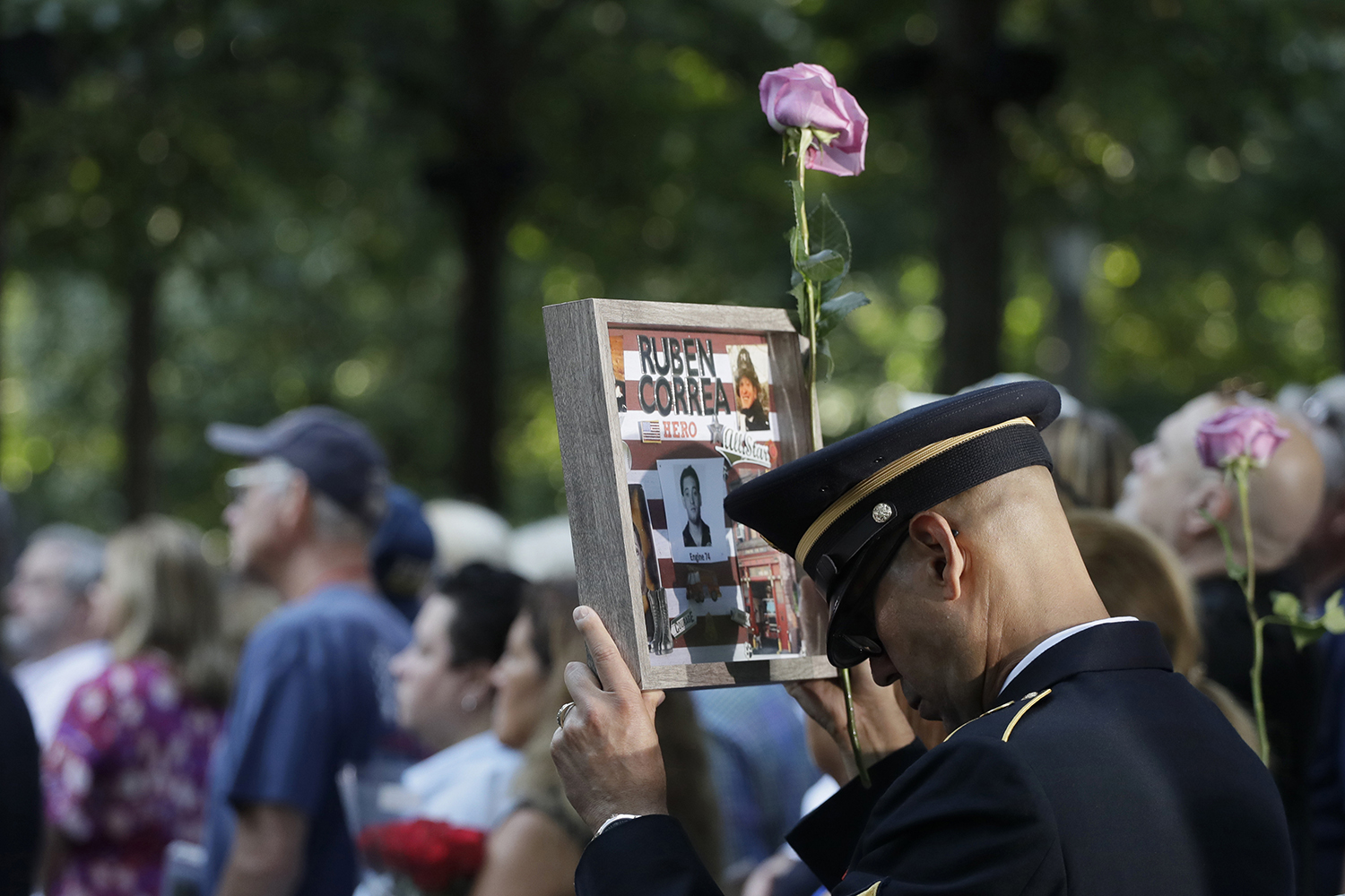 A man holds a photo of a victim during a ceremony marking the 18th anniversary of the attacks of Sept. 11, 2001, at the National September 11 Memorial, Wednesday, Sept. 11, 2019, in New York. (Mark Lennihan/AP)