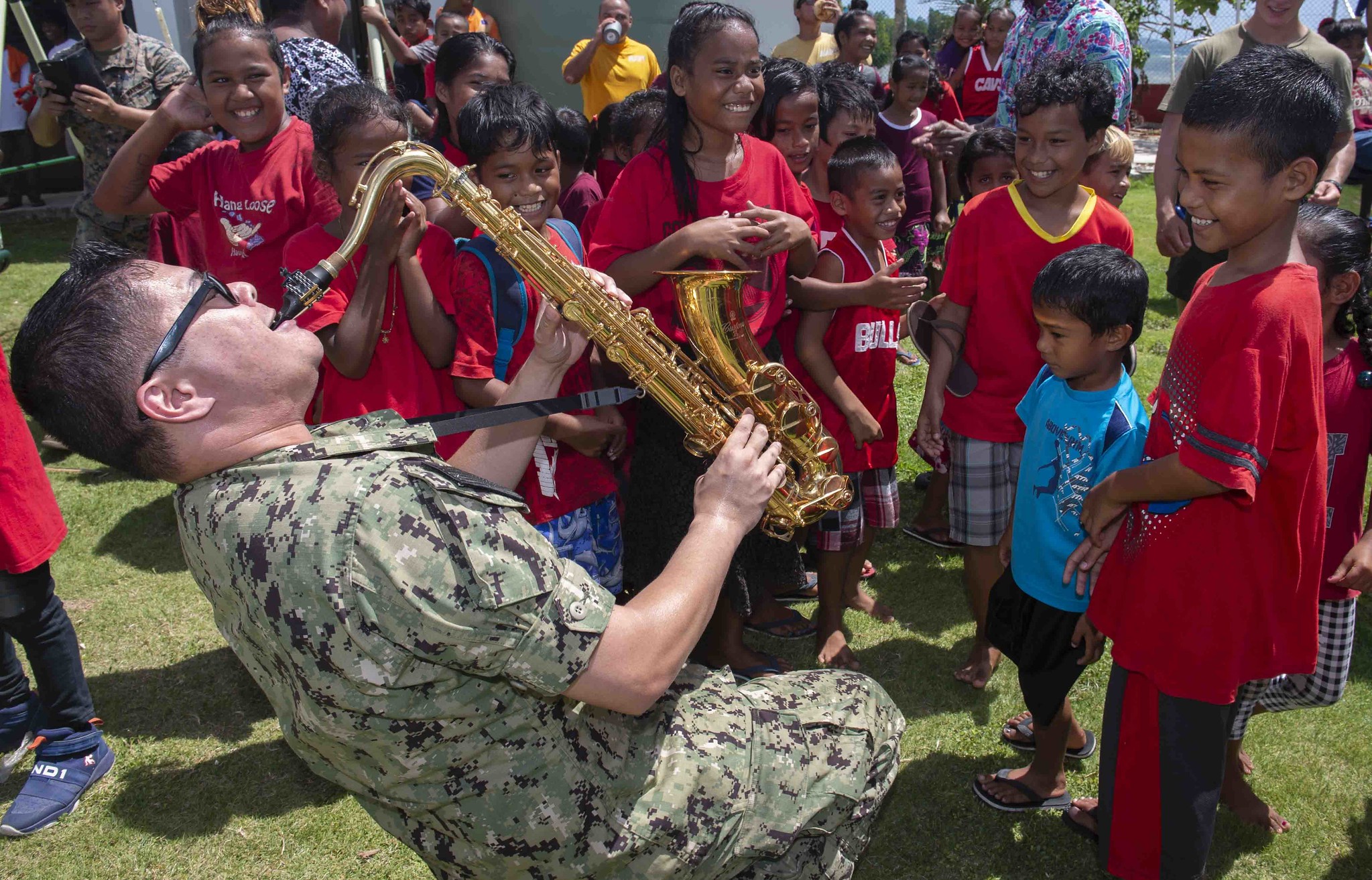 Musician 1st Class Andrew Francisco, a member of the Pacific Partnership 2019 Black Sands Brass Band, plays the saxophone for the students of Sapone Elementary School in Micronesia on April 22, 2019, during a concert to enhance community relationships during Pacific Partnership 2019. (Mass Communication Specialist 3rd Class Chanel Turner/Navy)