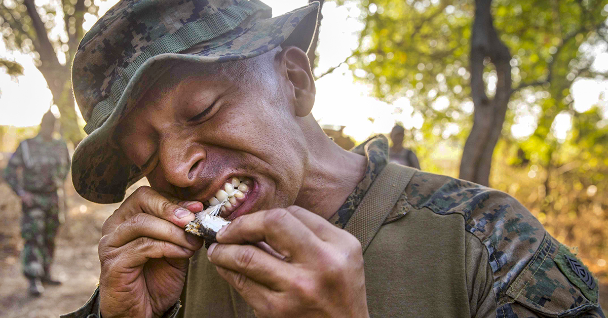 Marine 1st Sgt. Mauricio Grande, company First Sergeant of Kilo Company, Battalion Landing Team 3/1, 13th Marine Expeditionary Unit (MEU), bites into a cooked snake during Cooperation Afloat Readiness And Training (CARAT) Indonesia 2018. (Cpl. Danny Gonzalez/Marine Corps)