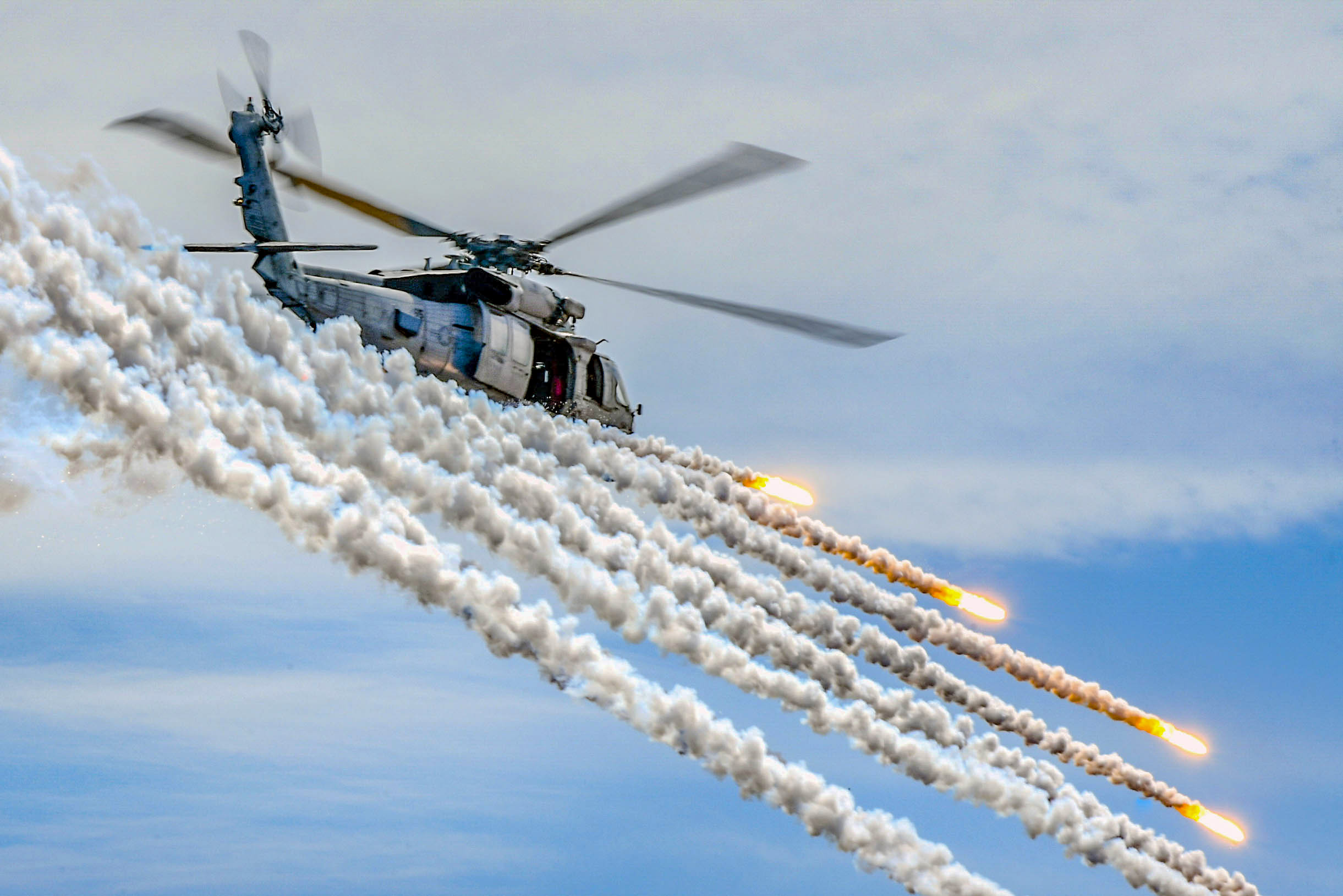 An MH-60S Sea Hawk, assigned to the Indians of Helicopter Sea Combat Squadron (HSC) 6, fires flares alongside the aircraft carrier USS Theodore Roosevelt (CVN 71) during an air power demonstration. Theodore Roosevelt is currently deployed in the Pacific Ocean. (U.S. Navy photo by Mass Communication Specialist Seaman Michael A. Colemanberry/Navy)