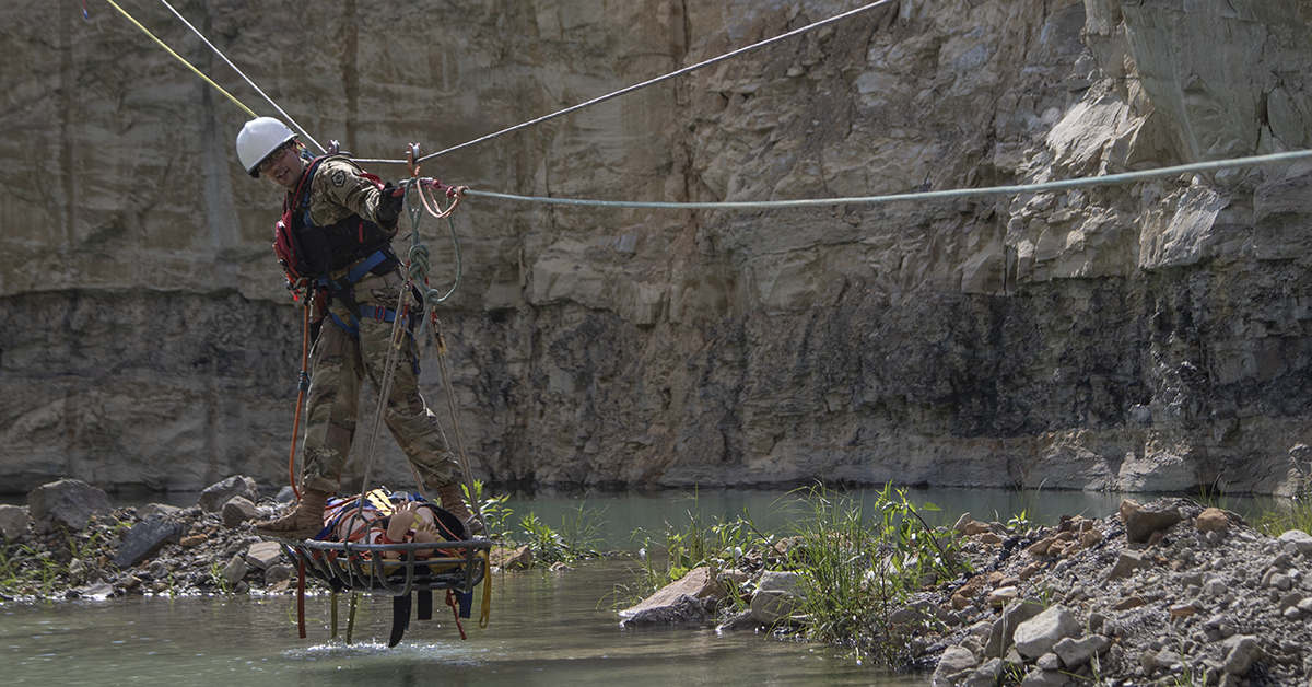 West Virginia Army National Guard Sgt. Brandon Garner is a litter attendant being pulled up a telpher line during Army Interagency Training Education Center rope rescue course from August 19-25 at Hobet mine site in Julian, West Virginia. (Spc. Brianna Lawrence/U.S. Army National Guard)