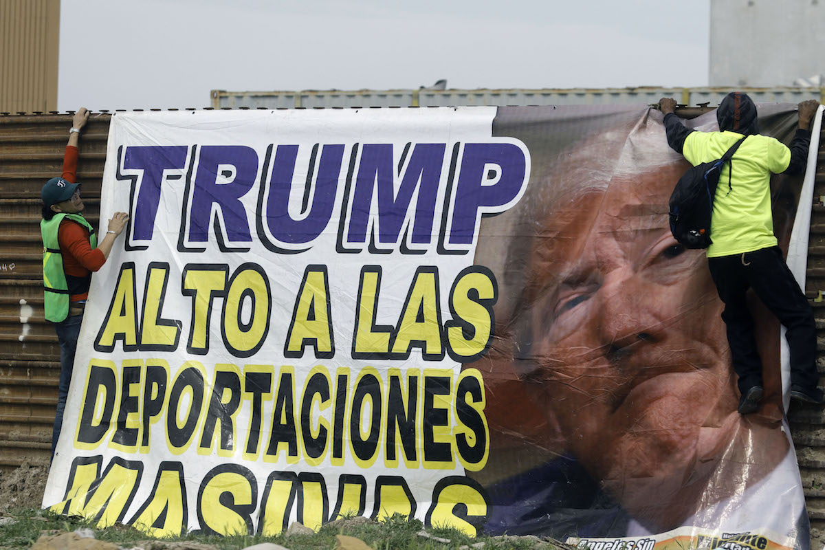Demonstrators place a banner reading