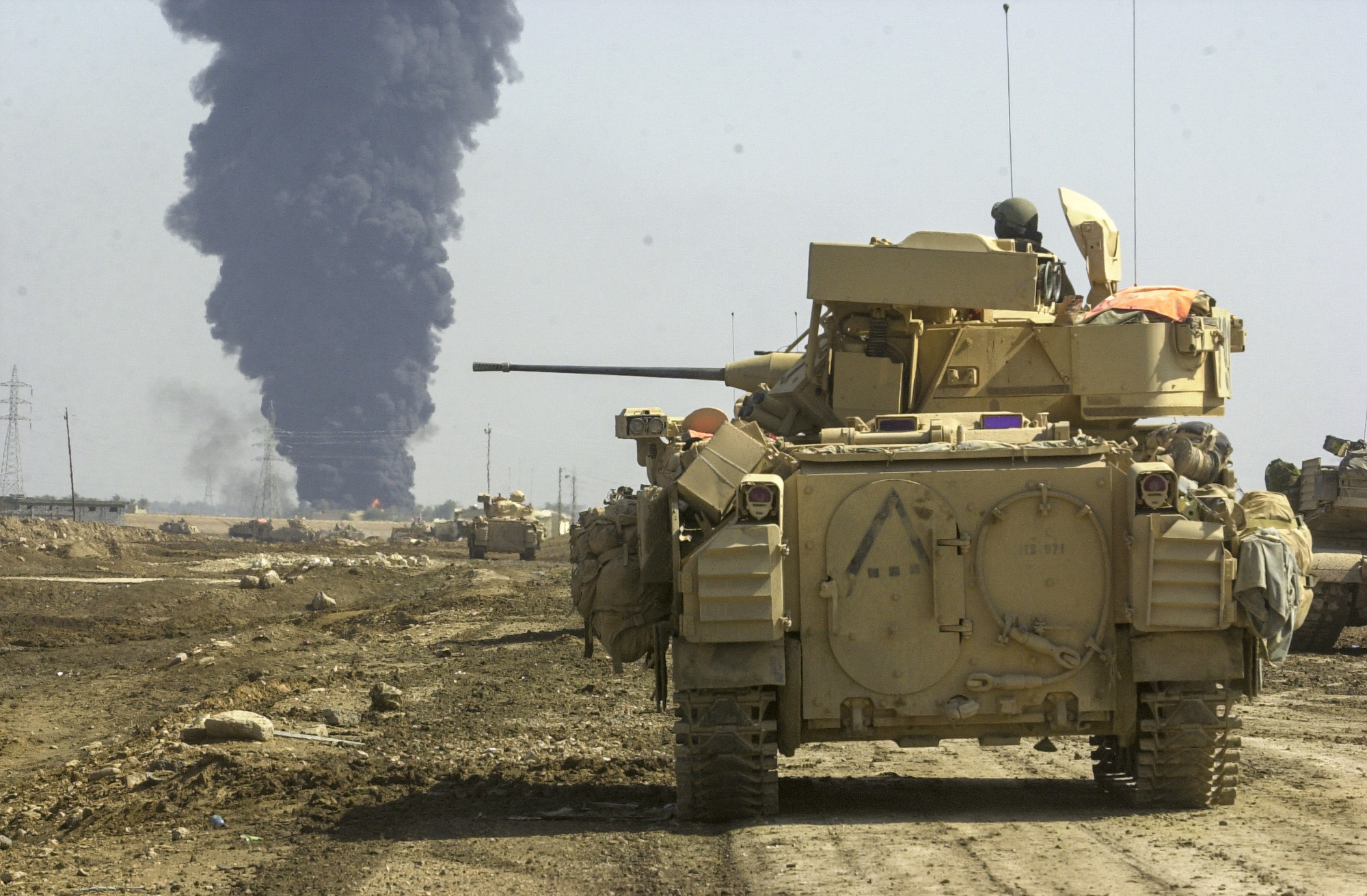 Troops from the U.S. Army's 3rd Squadron, 7th Cavalry Regiment watch as a target inside the village of As Samawah, Iraq goes up in flames. The Cavalry is in the process of taking the village and is receiving some resistance from fighters inside. (Warren Zinn/Army Times)