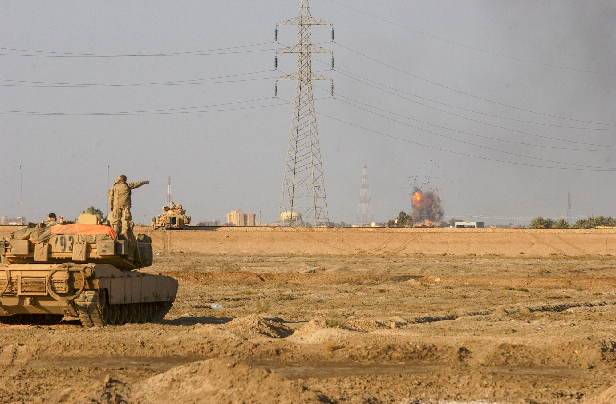 Soldiers from the U.S. Army's 7th Cavalry Regiment, watch on as a bomb from an F-16 blows up what was a headquarters for the Iraqi's that were fighting them. The troops have been operating around As Samawah for almost two days now and have been facing some strong resistance from the fighters inside. (Warren Zinn/Army Times)