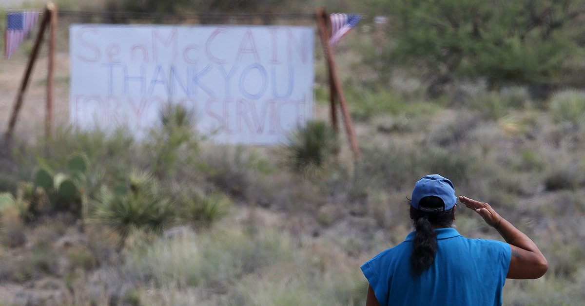 A military veteran pays his respects at the entrance to the Sen. John McCain's ranch complex in Cornville, Ariz., Saturday, Aug. 25, 2018. Sen. McCain, the war hero 2008 presidential candidate, passed away Saturday after a battle with brain cancer. (AP Photo/Ross D. Franklin)