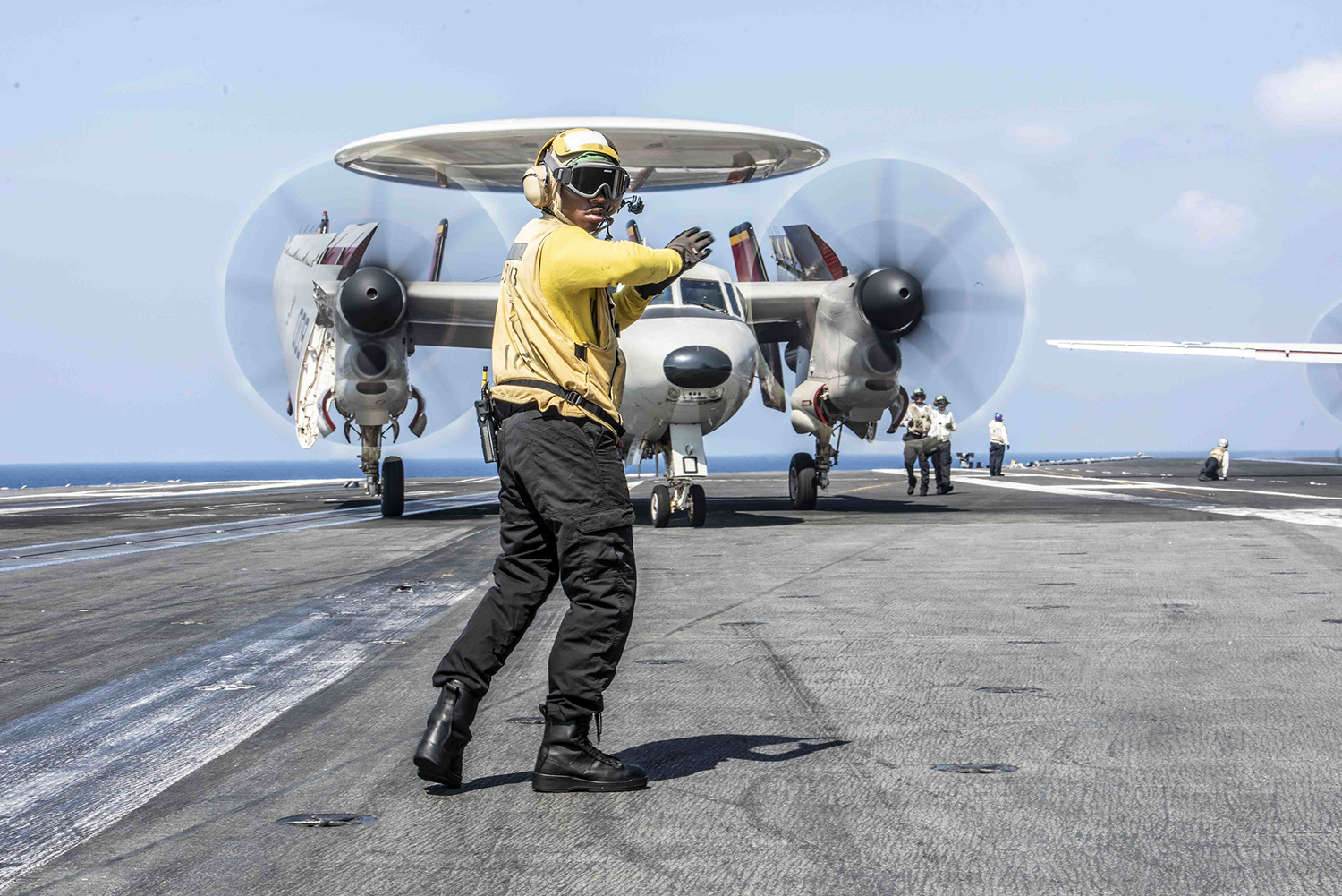 Aviation Boatswain's Mate (Handling) Airman Carlos Gamble, directs an E-2D Hawkeye aboard the Navy’s forward-deployed aircraft carrier USS Ronald Reagan (CVN 76) on Sept. 26, 2019, in the South China Sea. (Mass Communication Specialist 2nd Class Tyra M. Campbell/Navy)