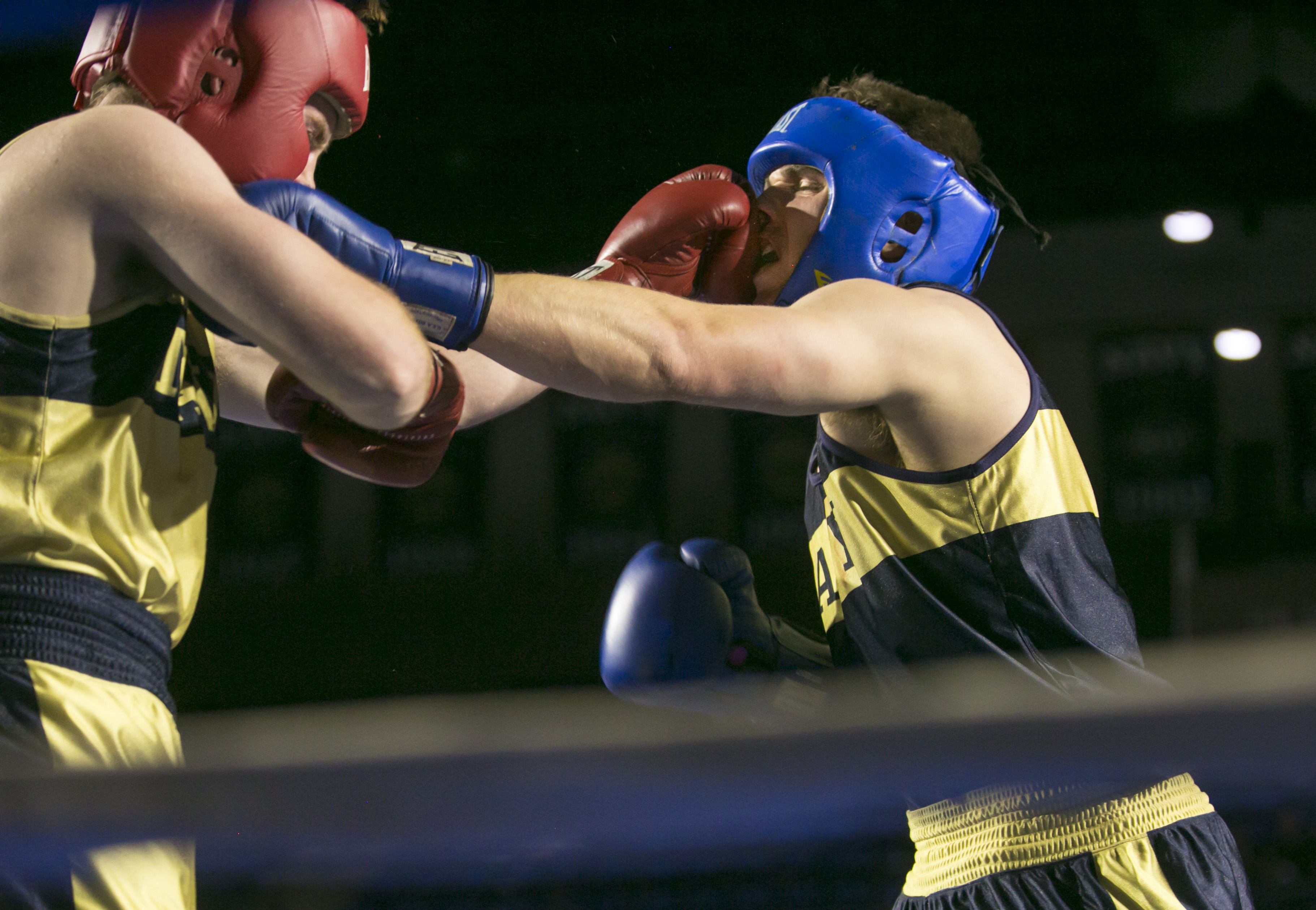 Jay Packer, (in gold) and Charlie Akerblom, (in blue), both from Philadelphia, PA, slug it out in the 185 lb weight class during the United States Naval Academy's 77th Brigade Boxing Championships held on Feb. 23, 2018. Akerblom won the fight. (Alan Lessig/Staff)