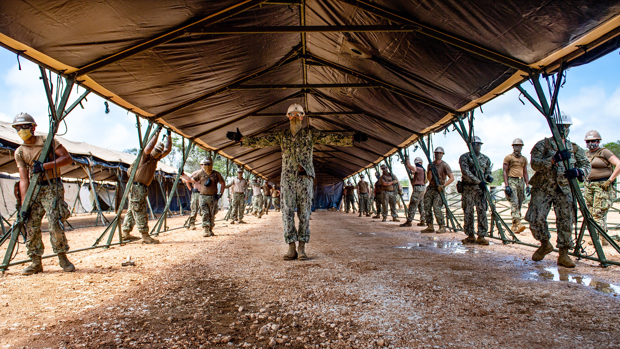 Sailors assigned to Task Force 75.5 prepare to lift a tent during construction of a 150-bed expeditionary medical facility at Naval Base Guam on April 21, 2020. (Mass Communication Specialist 1st Class Julio Rivera/Navy)