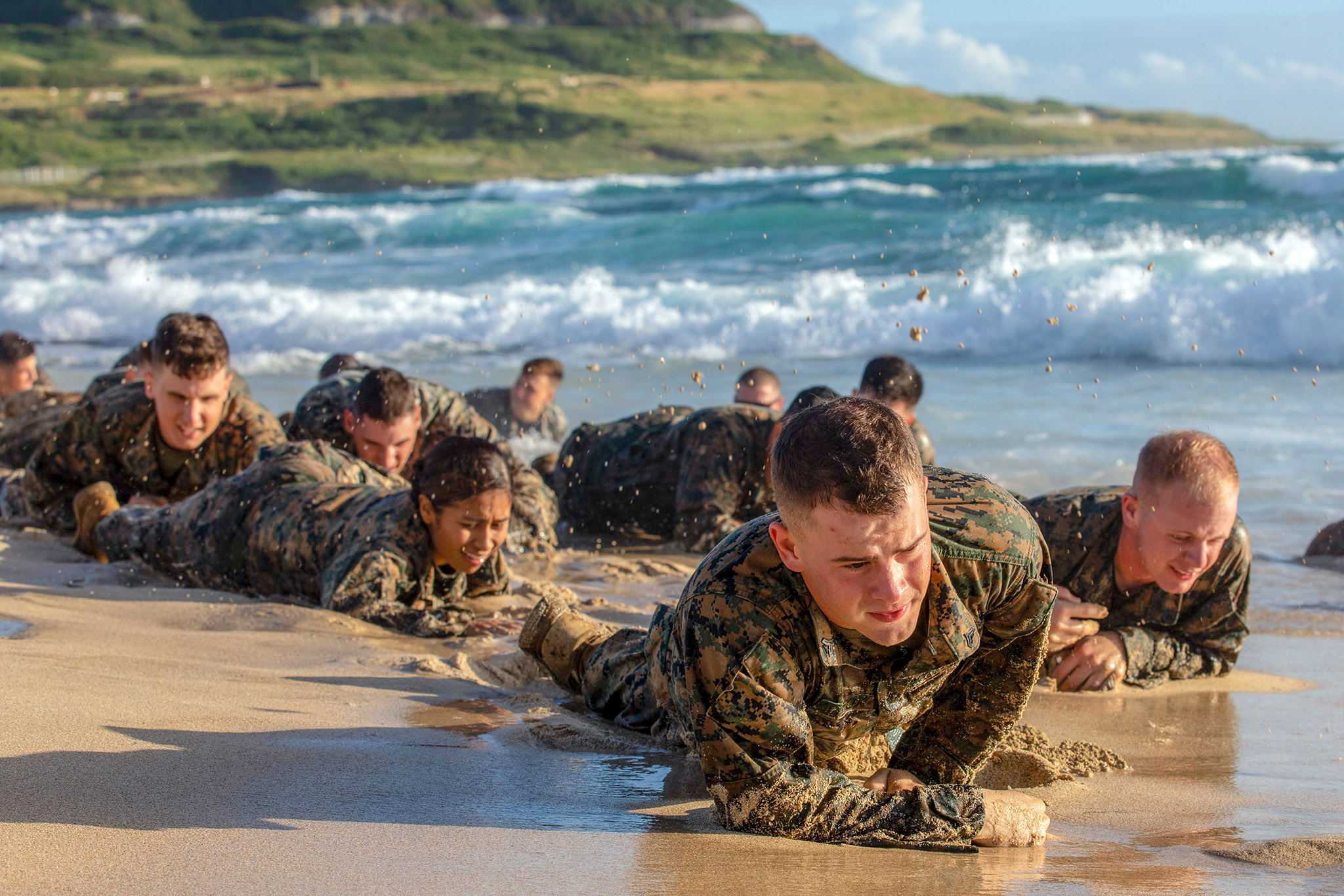 Marines attending the Corporals Course at Marine Corps Base Hawaii low crawl on Fort Hase Beach during a small unit leadership evaluation on Dec. 12, 2018, in Hawaii. (Sgt. Jesus Sepulveda Torres/Marine Corps)