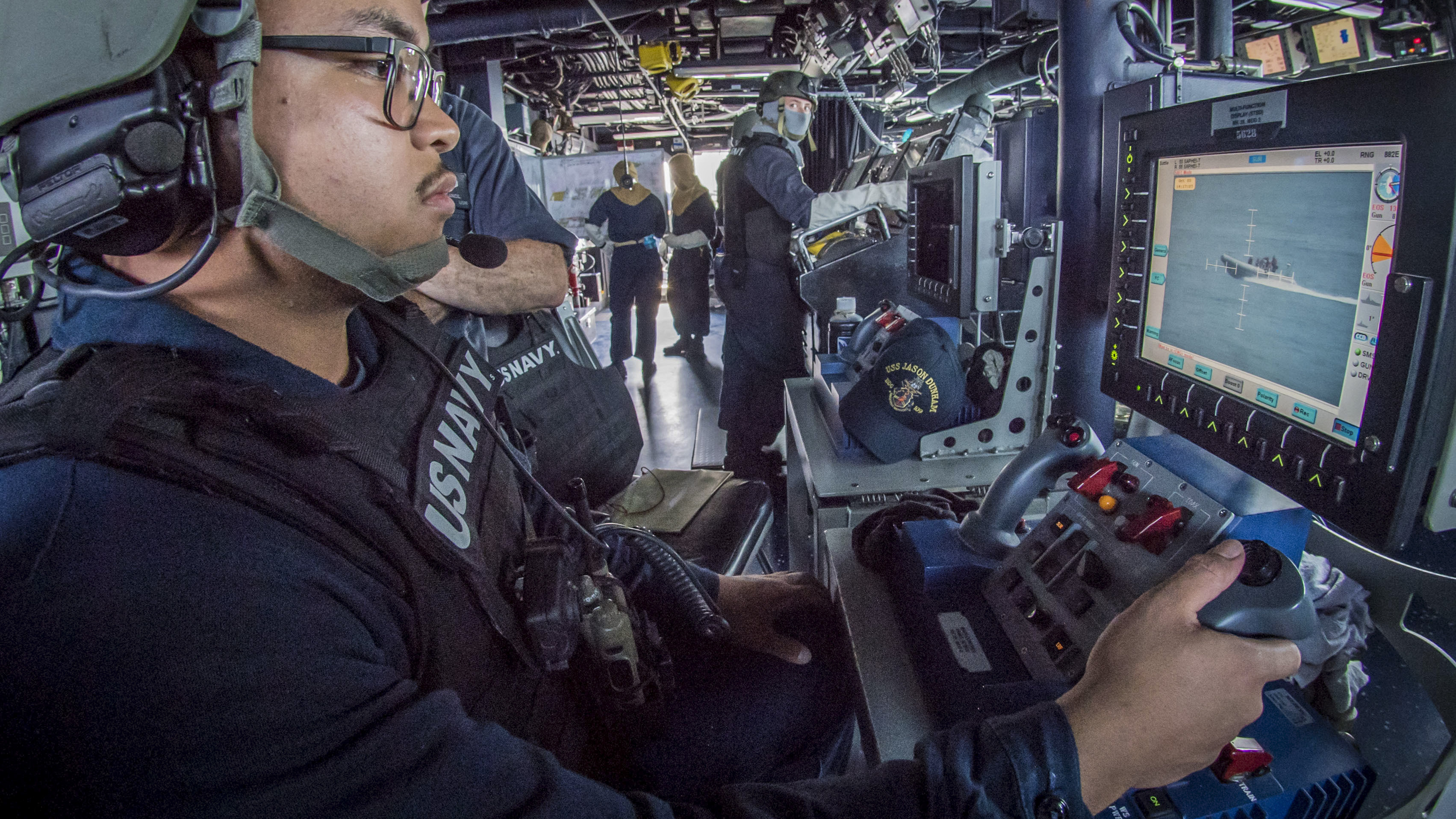 GunnerÕs Mate Seaman Mason Mendiola tracks a small boat with a remote operating console for the Mark 38 25 mm machine gun system during a general quarters exercise aboard the guided-missile destroyer USS Jason Dunham (DDG 109). Jason Dunham is deployed to the U.S. 5th Fleet area of operations in support of naval operations to ensure maritime stability and security in the Central Region, connecting the Mediterranean and the Pacific through the western Indian Ocean and three strategic choke points. (MC3 Jonathan Clay/Navy)