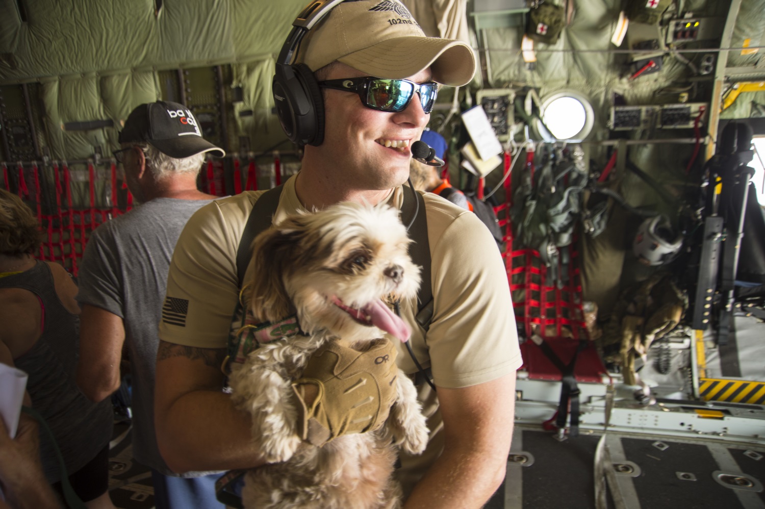 Capt. William Hall, HC-130 pilot with the 102nd Rescue Squadron, helps bring an evacuee's service dog on board an HC-130 headed to San Juan, Puerto Rico, on Sept. 10, 2017. (Staff Sgt. Erin Mills/Air Force)