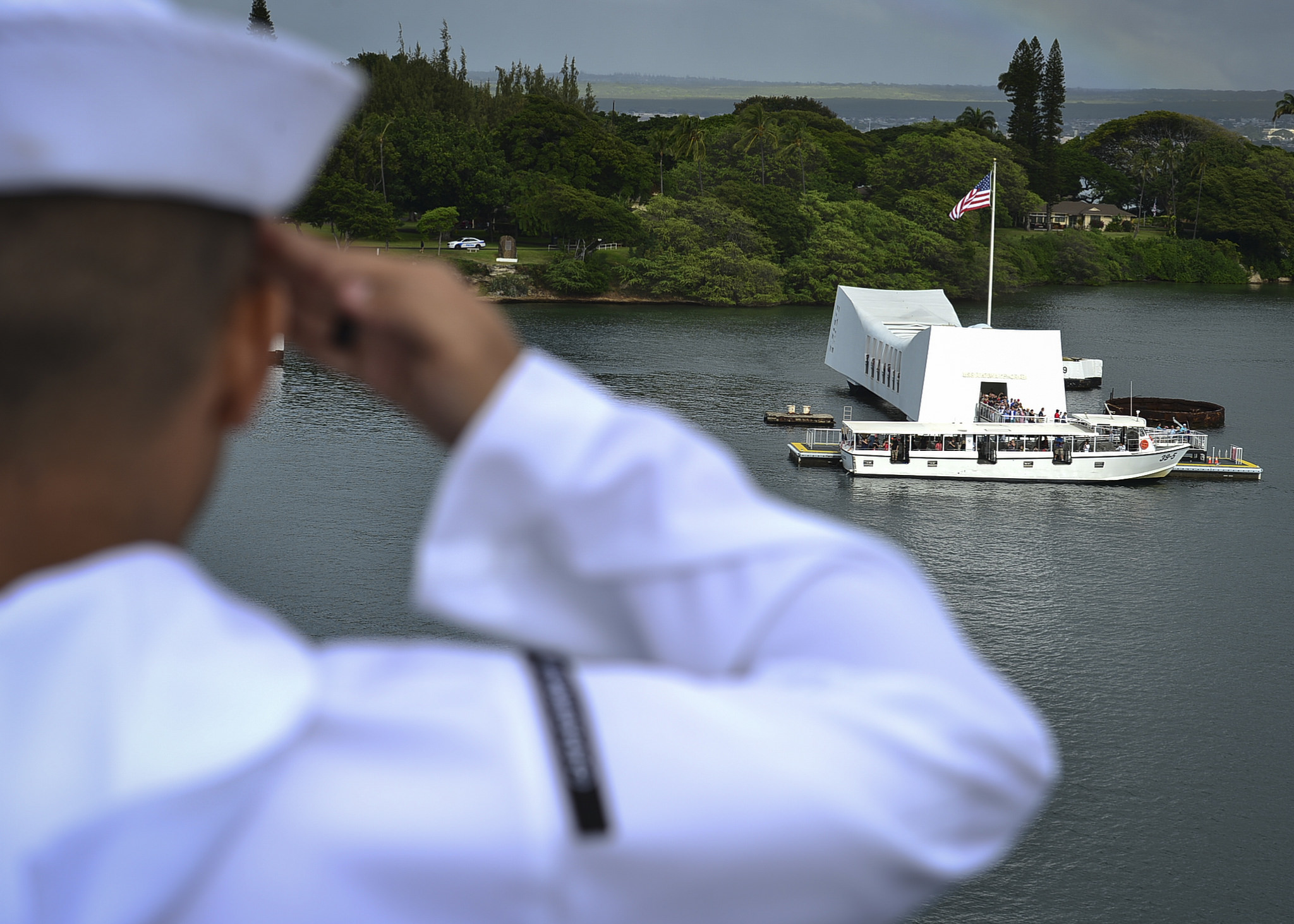 U.S. Navy sailors render honors aboard the aircraft carrier USS Nimitz (CVN 68) on Nov. 21, 2017, as the ship passes the USS Arizona Memorial at Joint Base Pearl Harbor-Hickam. (MC3 Cole Schroeder/Navy)