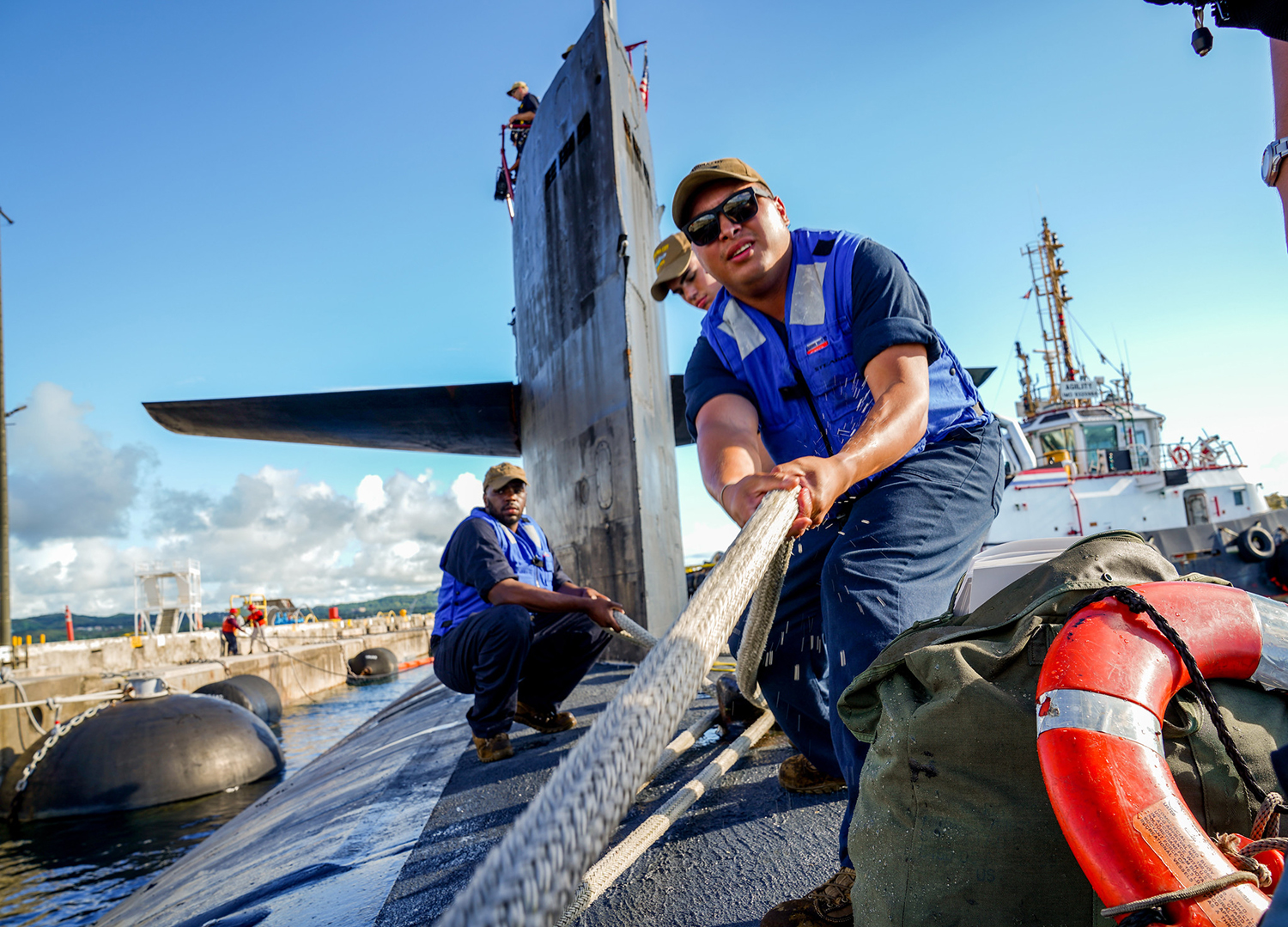 Sailors assigned to the Los Angeles-class fast attack submarine USS Oklahoma City (SSN 723) handle line Sept. 24, 2019, as the boat moors pierside at Apra Harbor, Guam, following a family day cruise. (Mass Communication Specialist 2nd Class Kelsey J. Hockenberger/Navy)