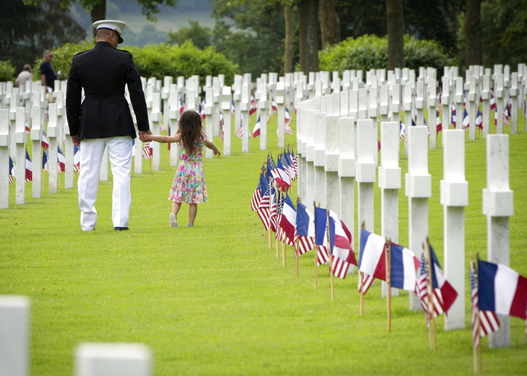A U.S. Marine walks with a small girl through headstones prior to a Memorial Day commemoration at the Aisne-Marne American Cemetery in Belleau, France, Sunday, May 27, 2018. The cemetery contains more that 2,000 American dead. (Virginia Mayo/AP)