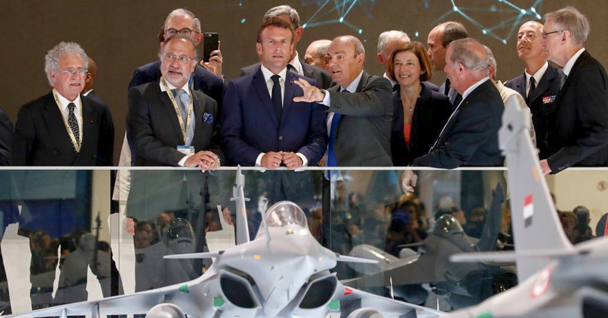 French President Emmanuel Macron, center, listens to Eric Trappier, chairman and CEO of Dassault Aviation, as he stands next to French MP Olivier Dassault, second from left, and French Armed Forces Minister Florence Parly at the Paris Air Show on June 17, 2019. (Benoit Tessier/AFP via Getty Images)