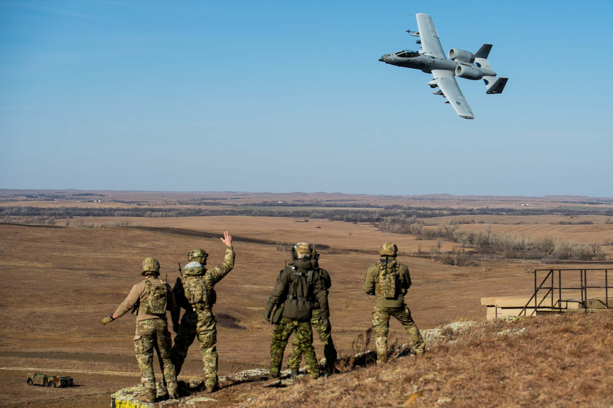 Members of the Oklahoma National Guard's 146th Air Support Operations Squadron and Estonian tactical air control party specialists acknowledge an A-10 Thunderbolt II during a show of force after completing close-air support training at Smoky Hill Air National Guard Range in Salina, Kan., Dec. 13, 2017. The Estonian TACPs traveled to the U.S. to work alongside members of the 146 ASOS to complete upgrade training and enhance multi-national relationships. This was the first time the 146 ASOS hosted the Estonian TACPs. (Sgt. Tyler Woodward/Air National Guard)