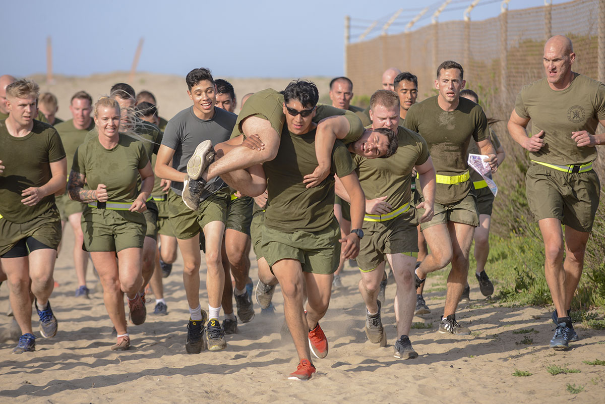 A Marine with 1st Intelligence Battalion, I Marine Expeditionary Force Information Group, I Marine Expeditionary Force, performs a fireman’s carry on a fellow Marine during a battalion physical training event at Camp Pendleton, Calif., April 13, 2018. The events offer opportunities for the companies of 1st Intelligence Battalion to compete against each other and build esprit de corps, morale and team work throughout the battalion. (Sgt. Timothy Valero/Marines)