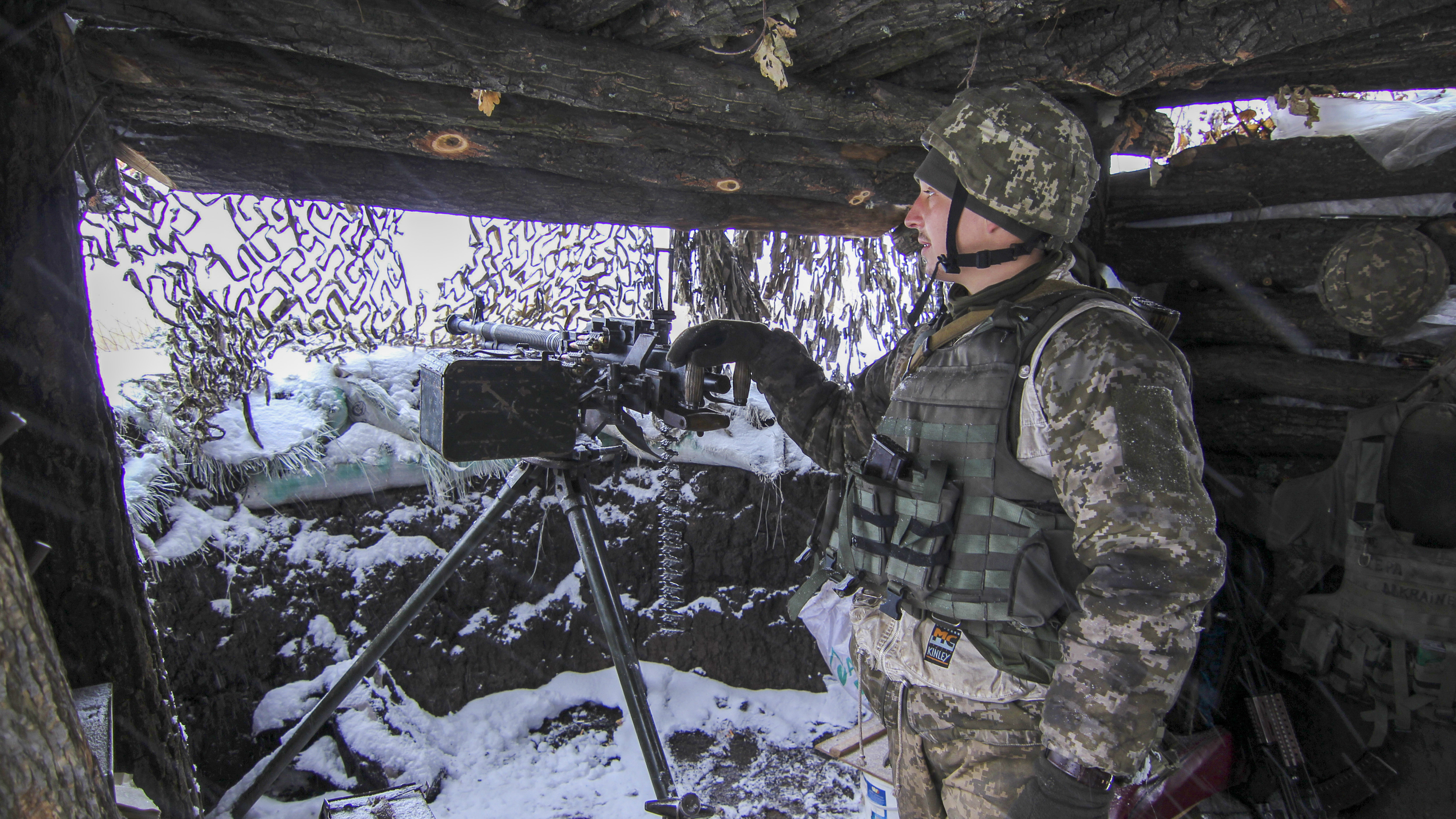 A Ukraine army soldier stands on duty with his heavy machine gun at an undisclosed location in eastern Ukraine, Monday, Nov. 26, 2018. Ukrainian lawmakers were set to consider a presidential request for the introduction of martial law in the country on Monday following an incident in which Russian coast guard ships fired on Ukrainian navy vessels. (AP Photo/Alexander Shulman)