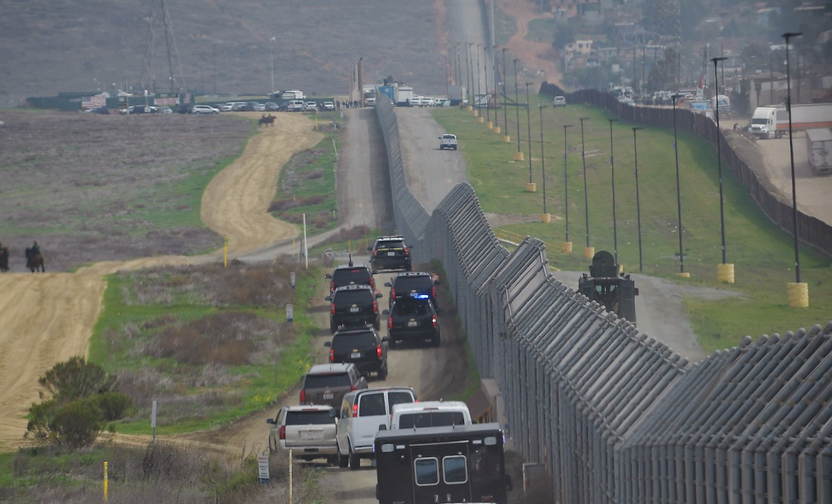 A motorcade carrying U.S. President Donald Trump drives past a U.S.-Mexico border fence as he heads for an inspection of border wall prototypes in San Diego, Calif., on March 13, 2018. (Mandel Ngan/AFP via Getty Images)